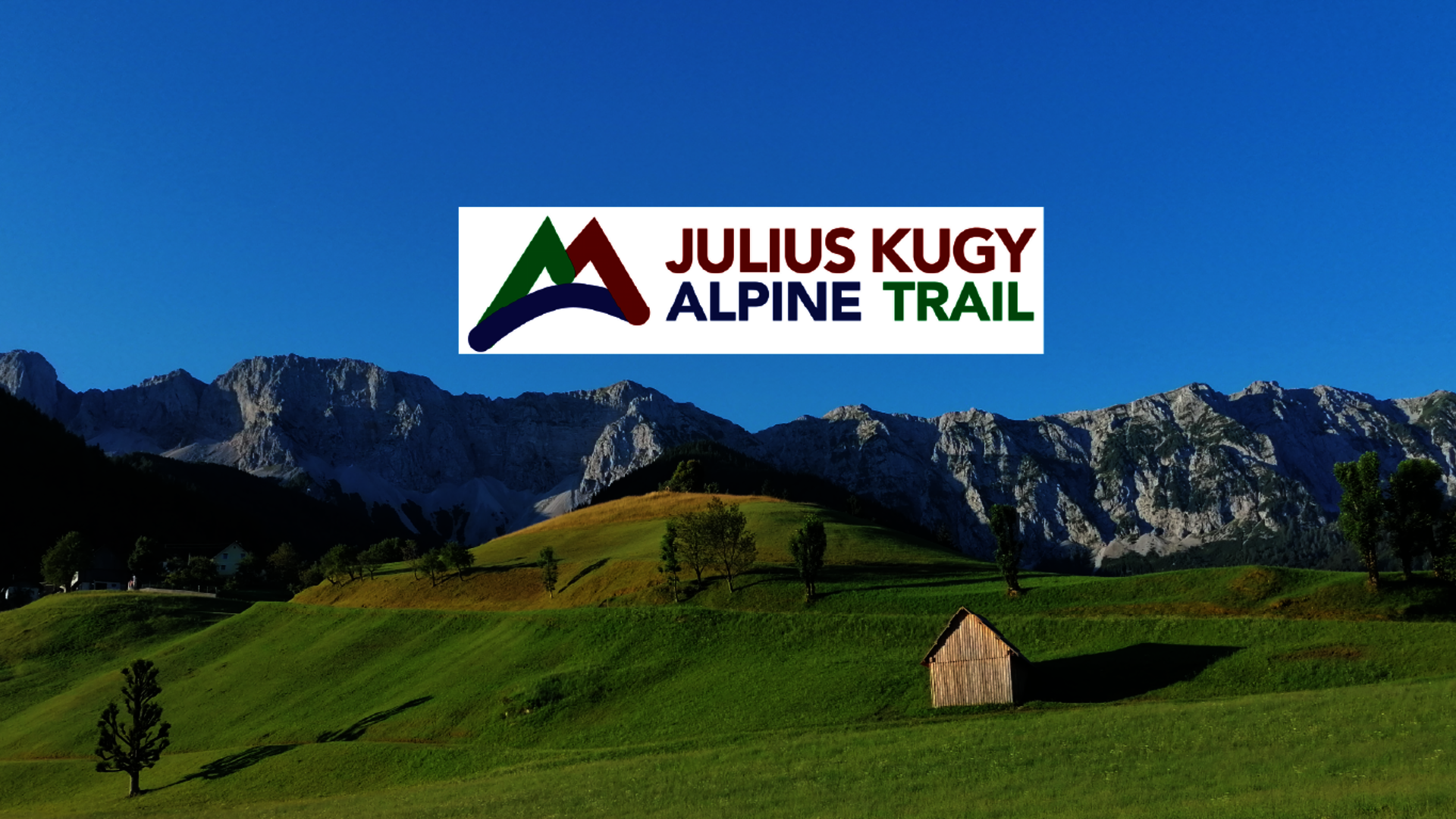 <p>Berglandschaft der Koschutta Kette mit Logo des Julius Kugy Alpine Trail.</p>