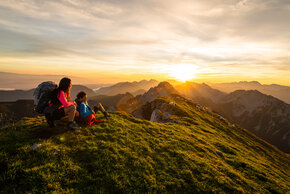 Wanderer im Sonnenaufgang auf den Berggipfeln der Karawanken im Rosental in Kärnten.