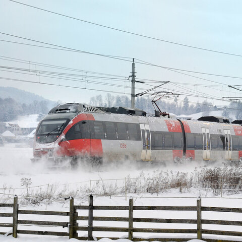 <p>Regionalzug der S-Bahn Kärnten bei der Anreise zum Advent in Velden in verschneiter Winterlandschaft.</p>
