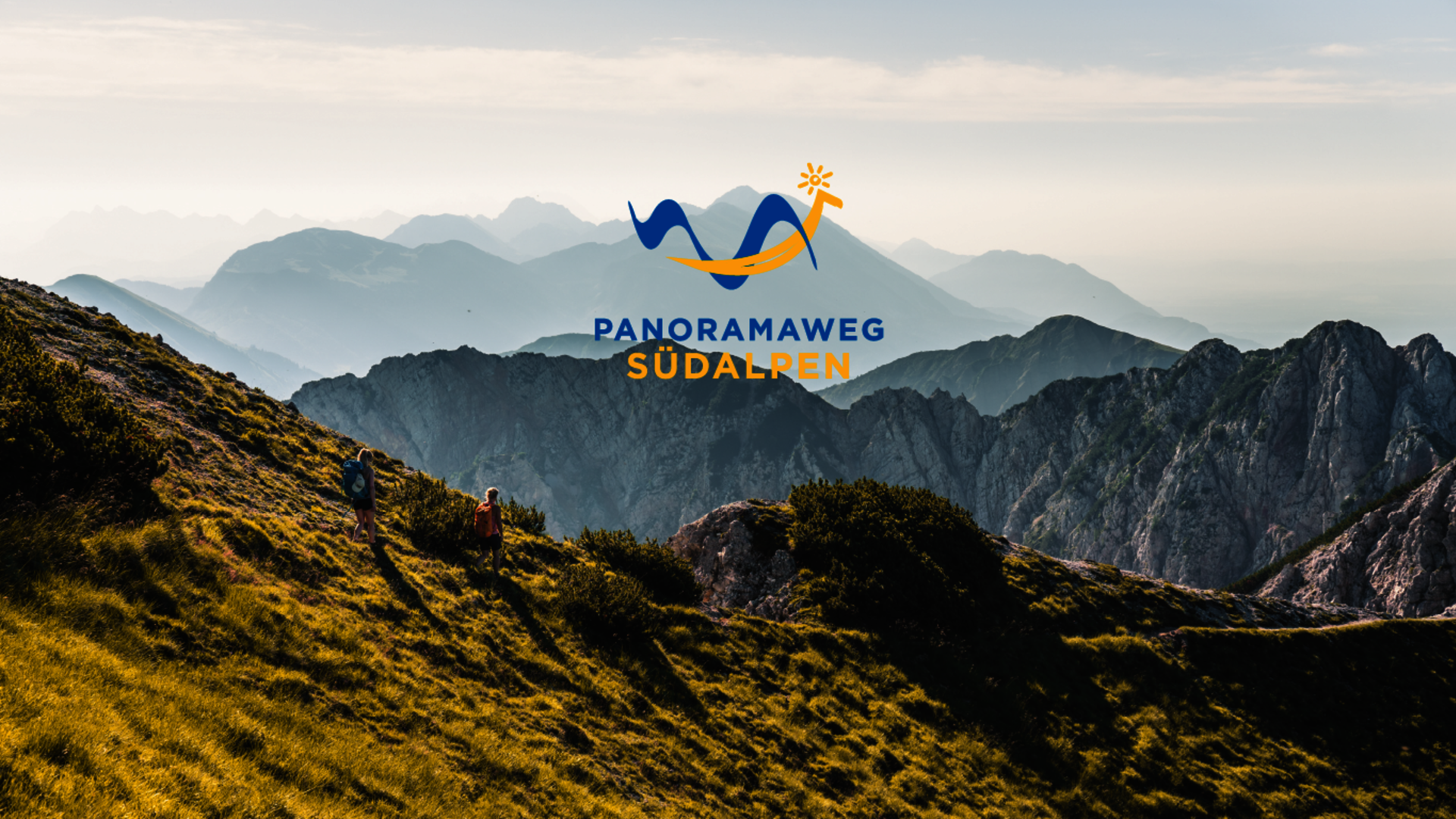 <p>Berglandschaft der Karawanken mit Wanderern und dem Logo des Panoramaweg Südalpen.</p>